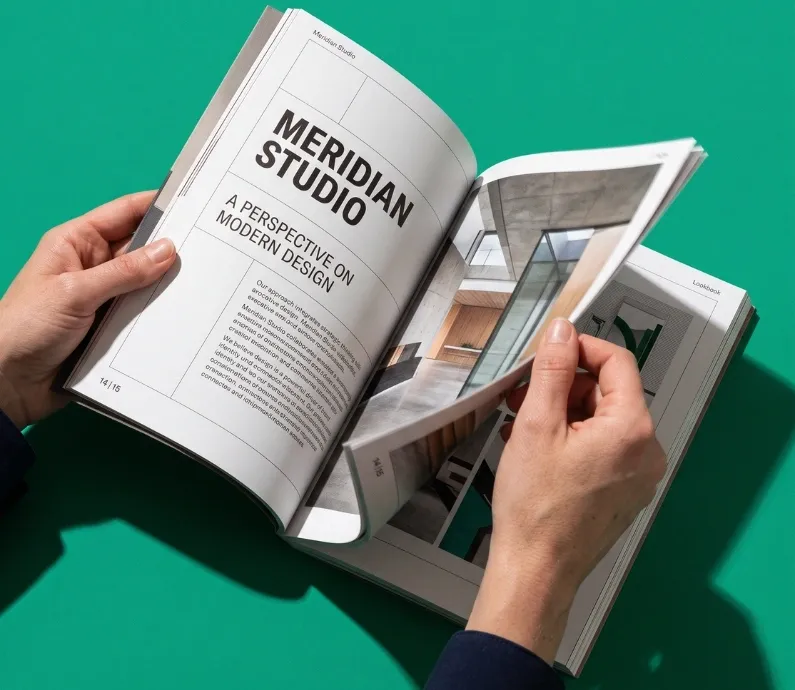 Hands holding an open printed booklet against a green background